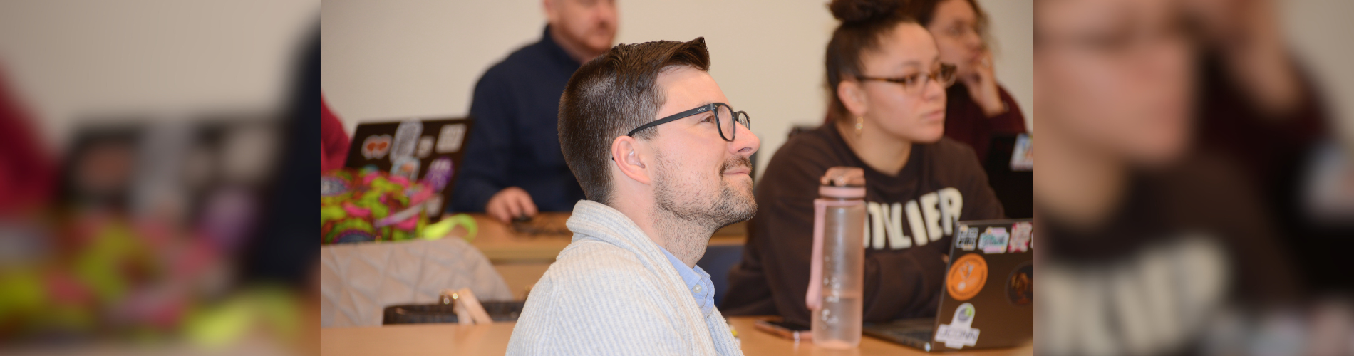 Four adult students sit in a classroom.