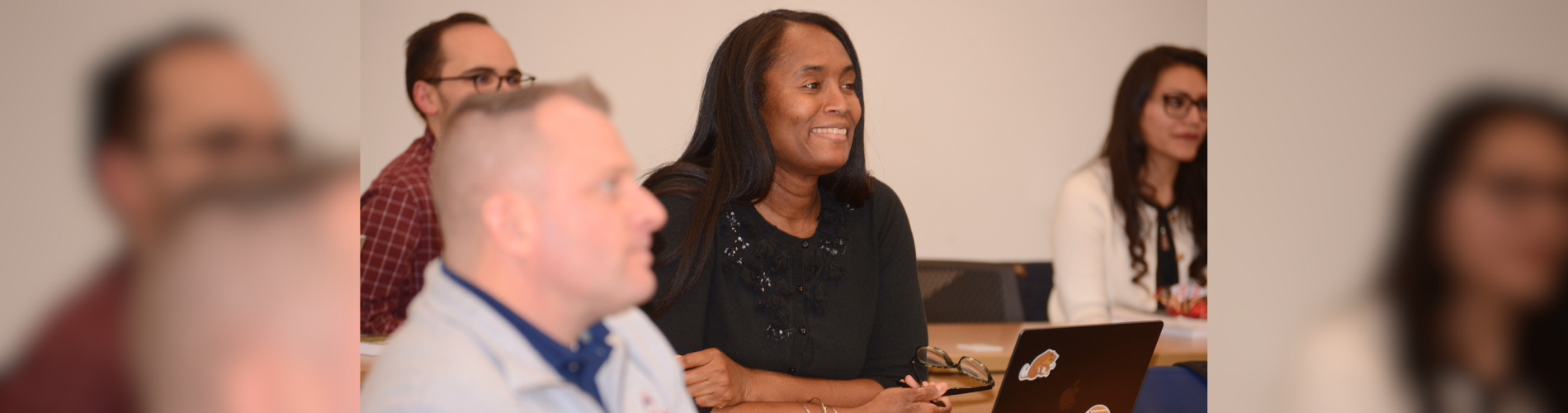 Four adult students sit in a classroom.